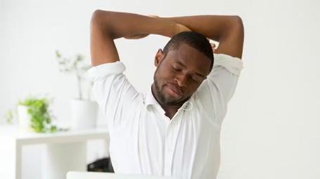 Man stretching in front of PC